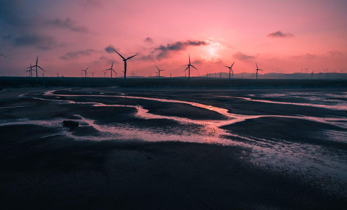 Picture of wind turbines with the sun setting in the background