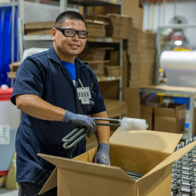 A Chromalox employee packing a box for shipping