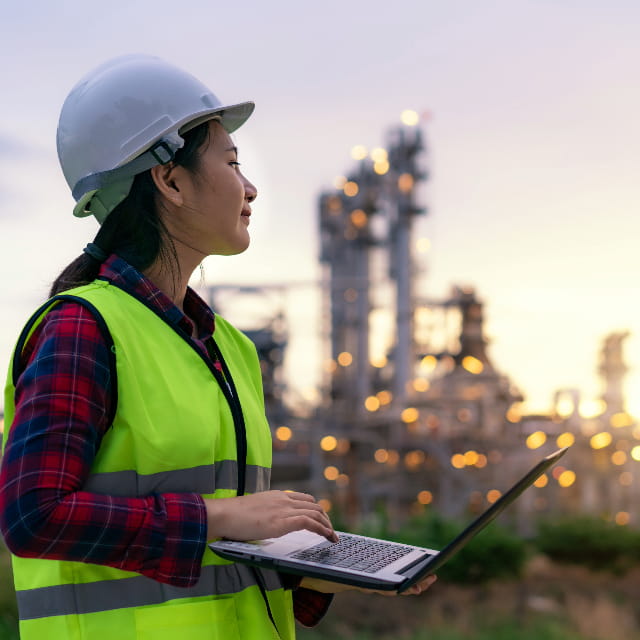 Engineer looking into the distance with industrial plant in background