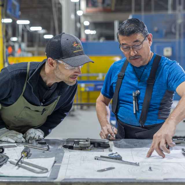 Two men look at a piece of paper