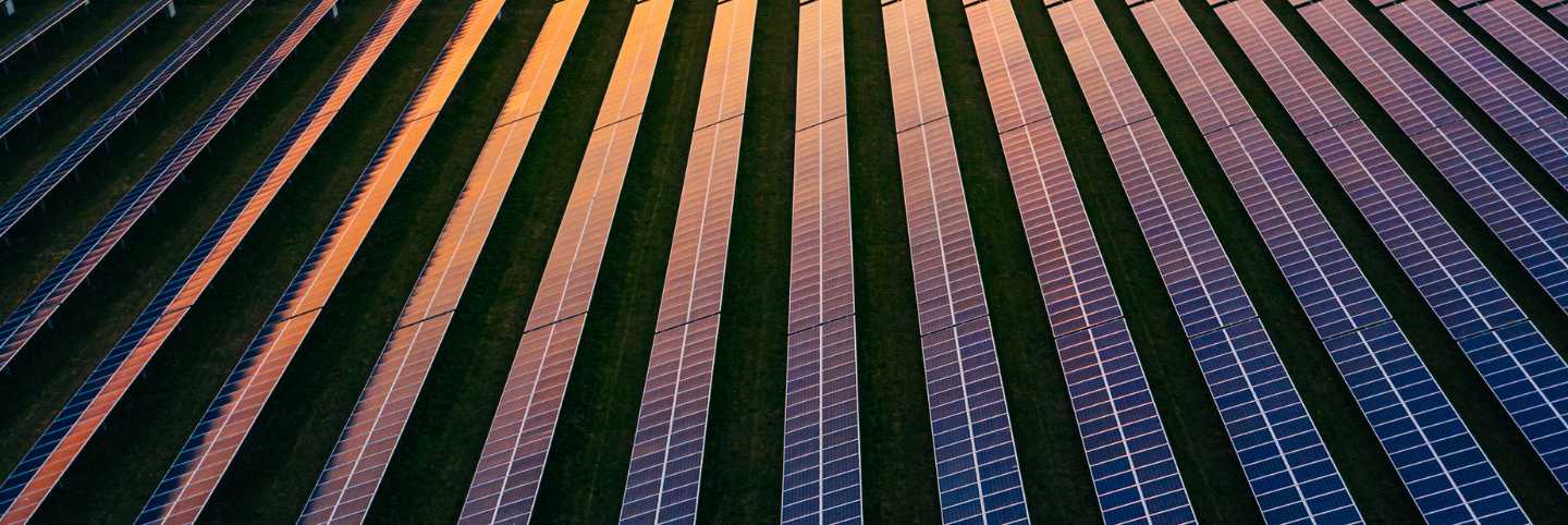 Sun setting over a field of solar panels 