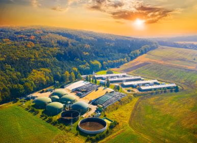 Biofuel plant with sun setting over the hills
