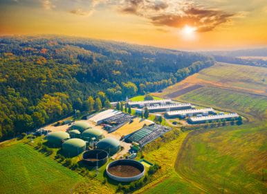 Biofuel plant with sun setting over the hills