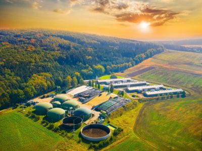 Biofuel plant with sun setting over the hills