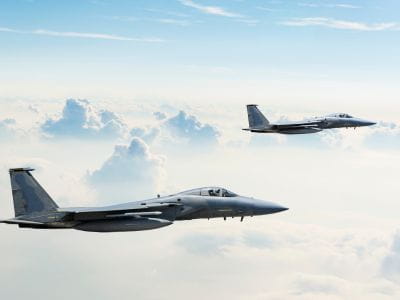 Two jet planes flying within the clouds