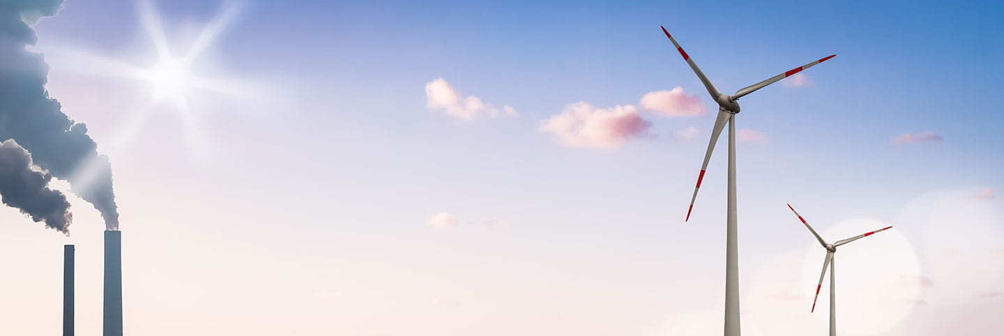 Sustainability image of sky with wind turbine and industrial chimney