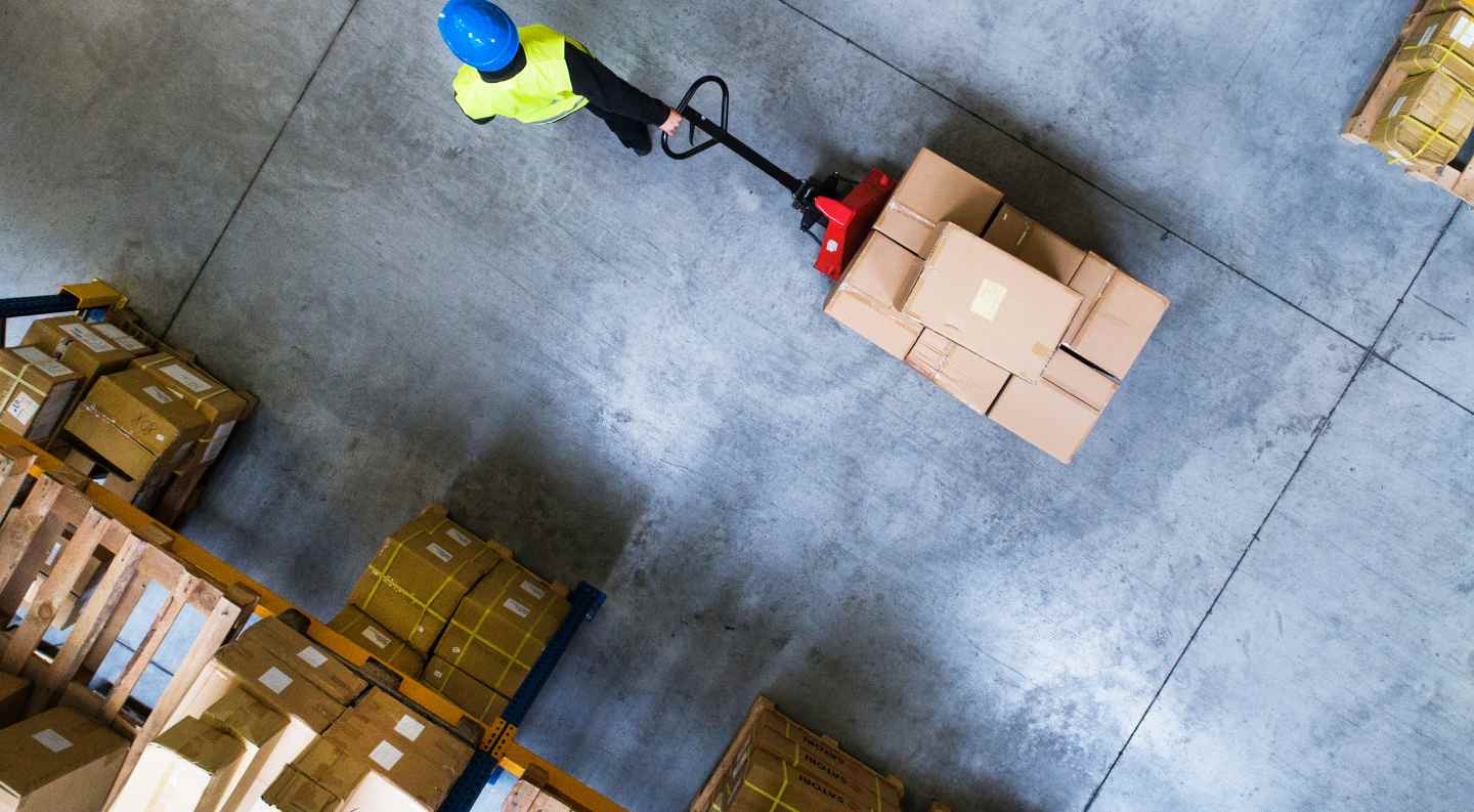 person moving through a warehouse with packages