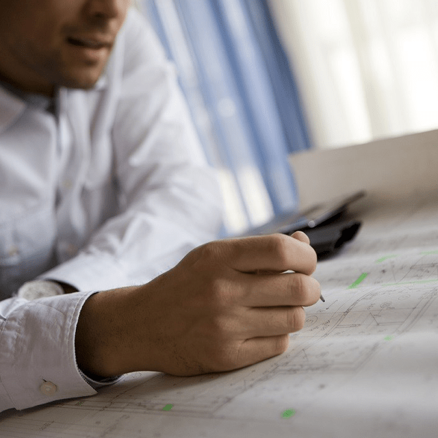 A person looking at a technical piece of paper